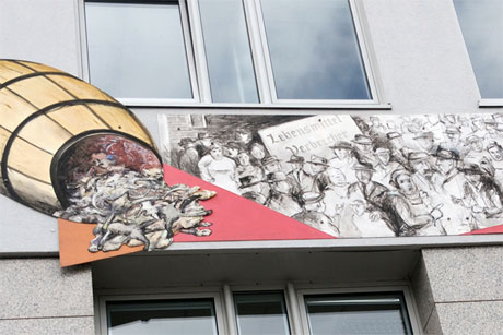 Seit 2015 erinnert ein Wandbild bei der Verbraucherzentrale in der Kirchenallee an die Sülze-Unruhen, (c) stahlpress Medie